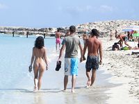 Heating up the beach by exposing her nude figure