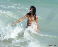 Two Women Laugh in the Rolling Waves at a Nude Beach