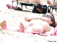 水平線に浮かぶ船を背景に、砂浜を歩く全裸の彼女
