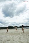 Two Nudists Standing on a Sandy Riverside Beach