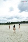 Two Nudists Standing on a Sandy Riverside Beach