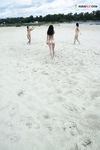 Two Nudists Standing on a Sandy Riverside Beach