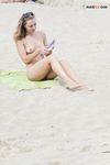 Rivista in mano in un pomeriggio rilassato in spiaggia naturista