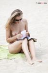 Rivista in mano in un pomeriggio rilassato in spiaggia naturista