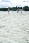 Three Friends Walk a Serene Stretch of Nude Beach Sand