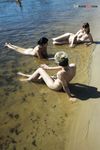 Due naturisti riposano e gesticolano accanto alle acque calme del fiume