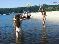 Due naturisti riposano e gesticolano accanto alle acque calme del fiume
