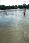 Due naturisti riposano e gesticolano accanto alle acque calme del fiume