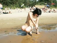 Rodeada de naturistas en una cálida playa de arena