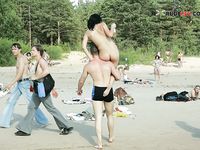 Quattro naturisti si rilassano insieme in spiaggia