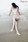 Quiet Shoreline Pause on Damp Nude Beach Sand