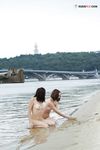 Wet Sand Between Their Fingers at a Calm Lake Shore