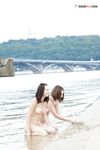 Wet Sand Between Their Fingers at a Calm Lake Shore