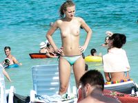 Two nudist ladies with juicy boobs swim in the sea at a naked beach