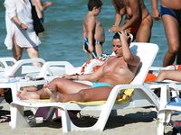 This cute brunette flaunts her perfect, firm tits while sitting topless and sunbathing outdoors