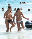 Two dark-haired hotties sit in the sand topless, tanning their slim bodies and firm tits 2