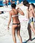 Dark-Haired Woman Walks a Topless Beach in White Bikini Bottoms