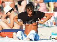 She spreads her legs to catch most of the sun and shows off her trimmed pussy