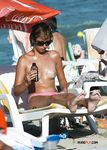 Multiple girls sit around in the sand and enjoy their day with perky tits and firm butts showing completely