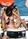 Multiple girls sit around in the sand and enjoy their day with perky tits and firm butts showing completely