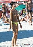 Multiple girls sit around in the sand and enjoy their day with perky tits and firm butts showing completely