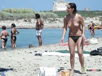 Beautiful brunette cuties with slim bodies and perky tits enjoy a sunny day at the beach sunbathing