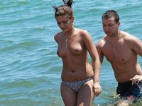 Nudist wife caught on camera setting up camp naked with her husband at the beach