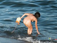 Rolling Waves Meet Bare Feet on Sandy Nude Beach Sand