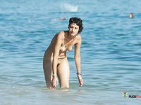 Curvy MILF with massive tits shows her naked body in family nudist camp as she goes out of the water to chill on the beach