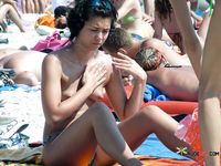 Topless Sunbathers Unwind on a Sandy Naturist Beach