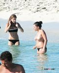 This nude beach girl enjoys tanning her fit, slim body with a pair of supple, rounds breasts on display