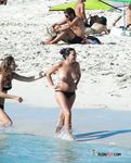 This nude beach girl enjoys tanning her fit, slim body with a pair of supple, rounds breasts on display