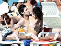 Multiple beautiful brunettes with slim bodies and perky tits fool around in the water and walk on the beach topless