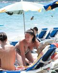 Beautiful nudist blonde fools around with her man at the beach