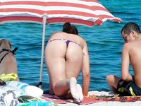 Amateur wives are having a laugh together while on crowded naked beach as they are revealing their natural tits and trying to catch some sun 2