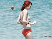 Un tranquilo paseo topless con vistas al océano en orilla soleada