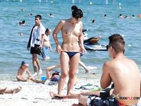 Un tranquilo paseo topless con vistas al océano en orilla soleada