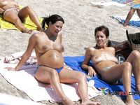 She sits around and relaxes with her massive, natural breasts and her smooth pussy on display 2