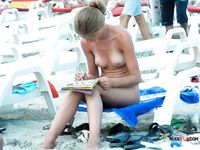 This dazzling blonde sits on the rocky beach topless and enjoys her day, unaware she's being filmed