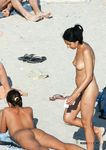 Spacer plażą obok opalających się na ręcznikach
