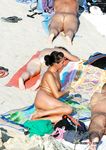 Spacer plażą obok opalających się na ręcznikach