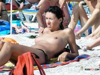 Two breathtaking brunettes with tight, fit bodies and beautiful, natural breasts walk around topless and lie down sunbathing 2