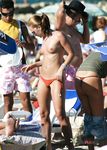 Playful teenies walk around topless, with their perky tits hanging out, and fool around in the water