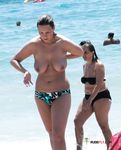 She enjoys tanning her massive, natural breasts topless after having left the water