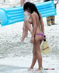 She enjoys tanning her massive, natural breasts topless after having left the water