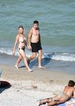 Two Topless Women Standing in Clear Sea Water
