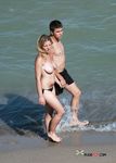 Two Topless Women Standing in Clear Sea Water
