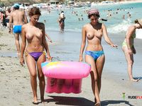 Two Topless Women Standing in Clear Sea Water