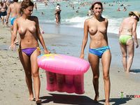 Two Topless Women Standing in Clear Sea Water