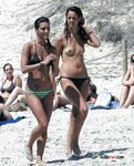 Nahé opalování u fotbalového míče a dalších plážových hostů